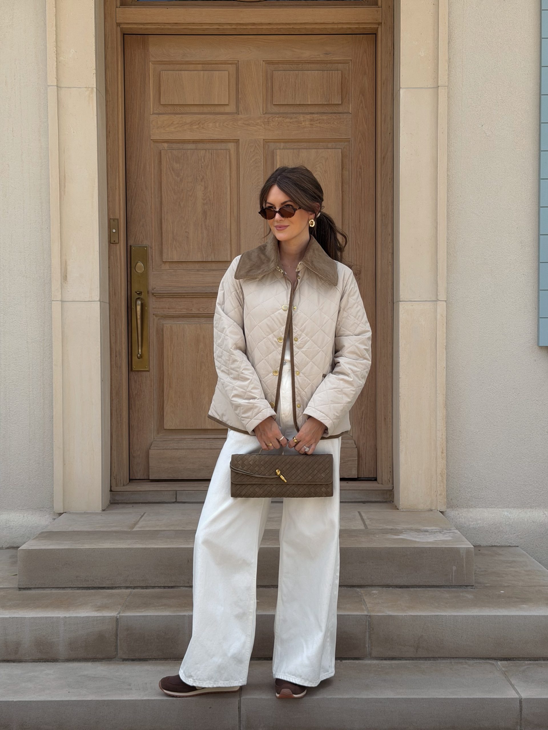 barbour quilted cream jacket, white jeans, brown suede sneakers, suede woven handbag for a fall 2026 outfit